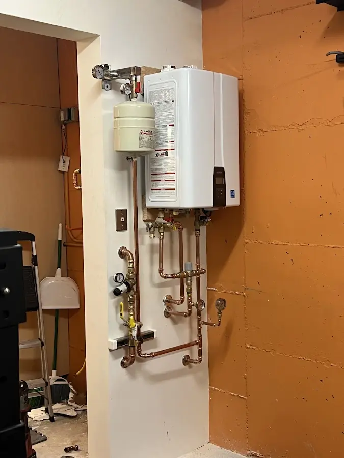 Plumbing technician inspecting water heater connections in Frankenlust